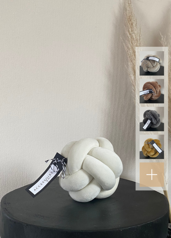 Handgefertigtes Knotenkissen in Größe S aus Samt in cremeweiß, abgebildet auf einem schwarzen Tisch. Auf der rechten Seite werden kleine Icons mit den verfügbaren Farben des Kissens angezeigt: hellbeige, dunkelbeige, grau und goldgelb.