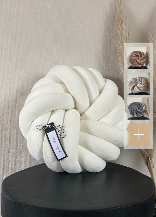 Swirl in cremeweiß Gr. L auf einem schwarzen Tisch. Daneben werden die weiteren Farben in einem Kästchen gezeigt. Diese sind dunkelbeige, hellbeige, grau und weitere.