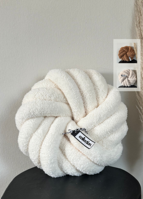 Handgefertigtes Swirl aus weichem Teddy in der Farbe cremeweiß, präsentiert auf einem schwarzen Tisch