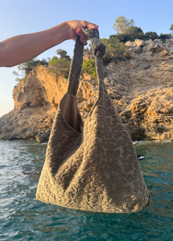Shopper aus weichem Leo Frottee in Khaki wird über das Meer in einer Bucht gehalten