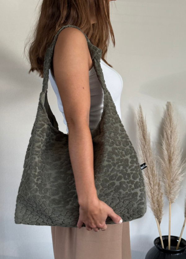 Designerin der Tasche trägt die Variante Leo Khaki Frottee.