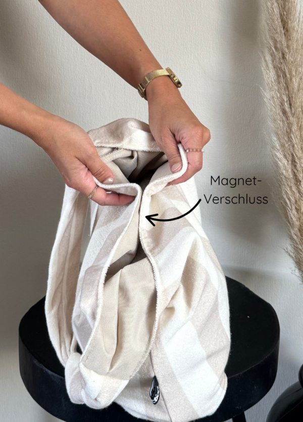 Der Shopper wird von oben gezeigt, die Hände zeigen wo der Magnetverschluss ist.