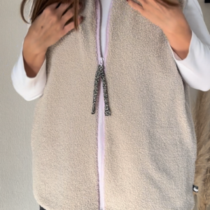 Vorderansicht der längeren Weste in der Farbe Hellbeige mit Fliederfarbenem Reißverschluss.